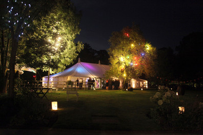 An external photo of a wedding marquee with colourful lights.